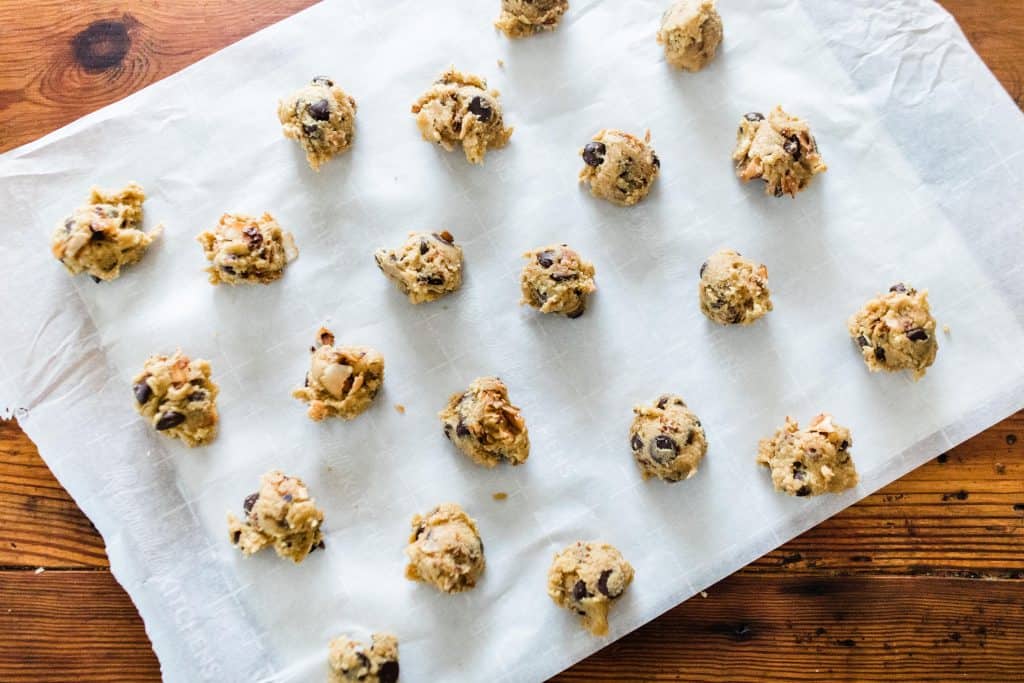 even scoops of cookie dough on a parchment lined cookie sheet