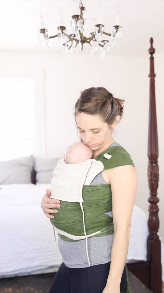 women wearing a olive green and tan DIY Mei Tai baby carrier with a baby in it