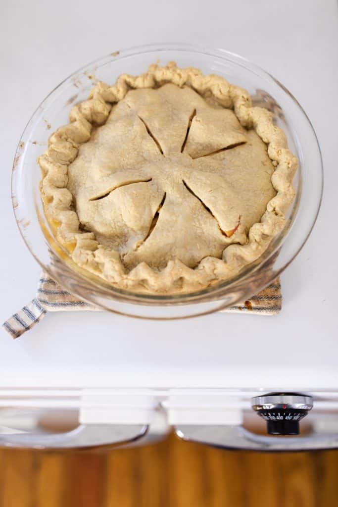 homemade apple pie straight out of the oven cooking on top of a vintage oven