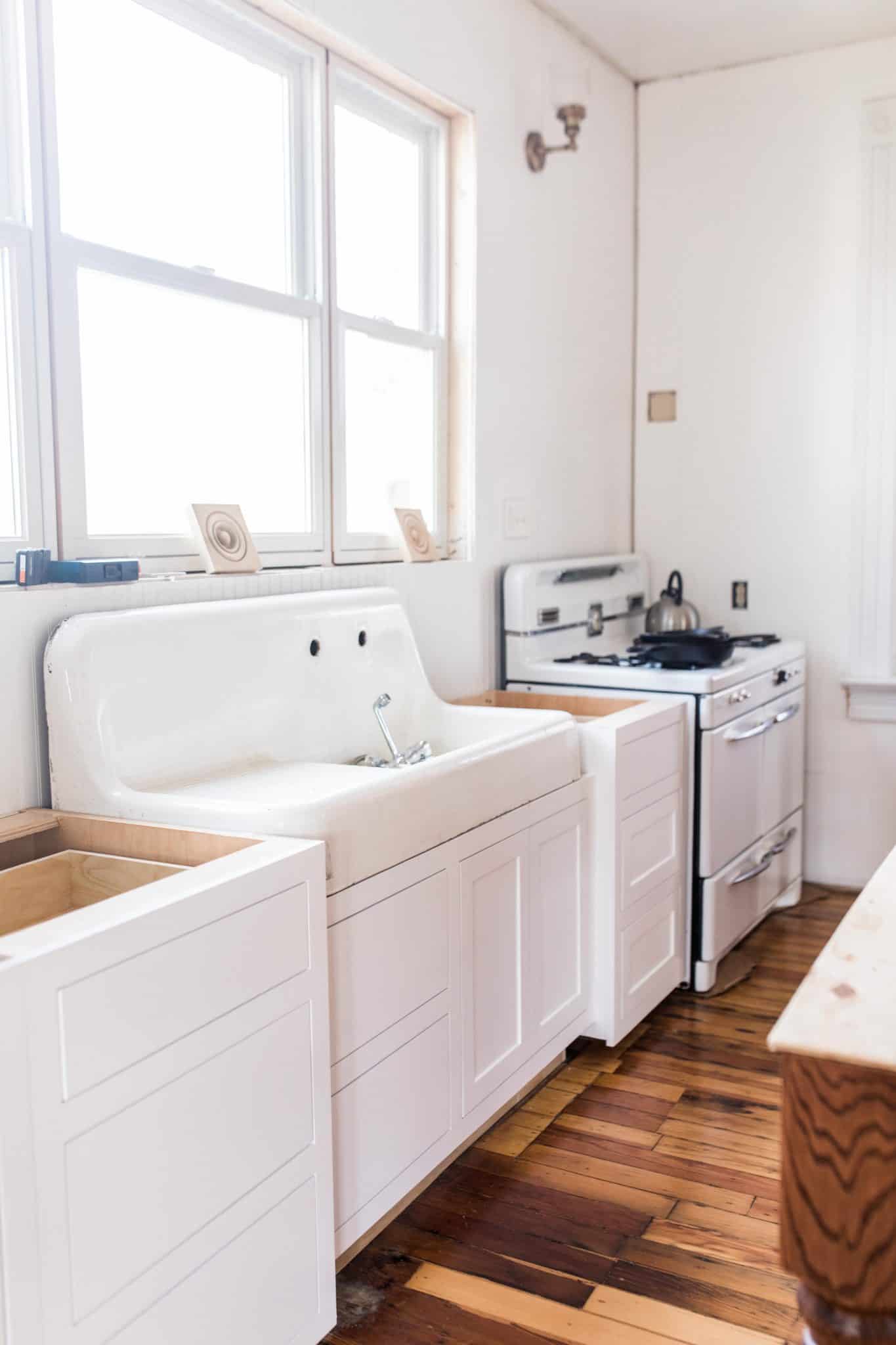 new white base cabinets, with a antique sink and custom cabinets below