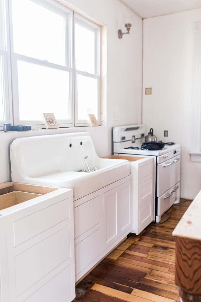 new white base cabinets, with a antique sink and custom cabinets below