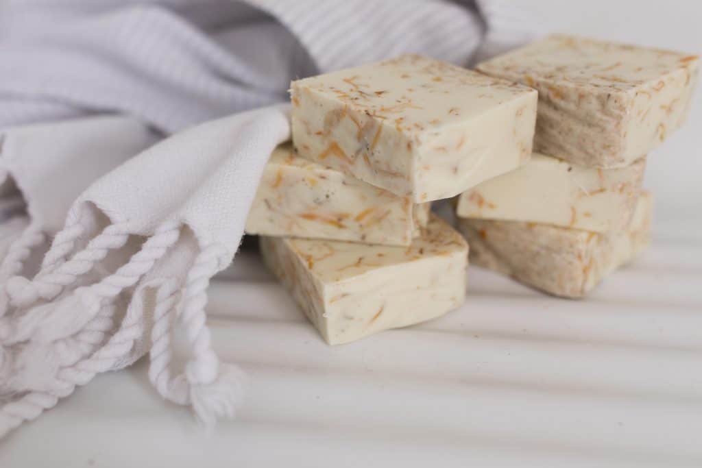 homemade goat milk soap on a counter next to a towel