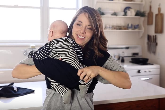women placing baby in the Baby K'tan with one leg through the fabric loop