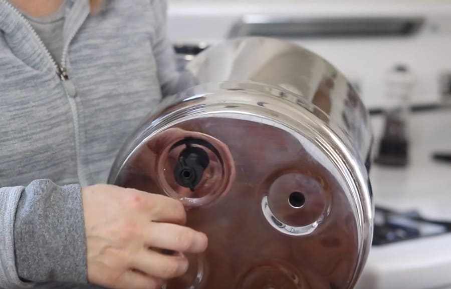 screwing on the plastic nut to the bottom of the top chamber of the Berkey water filter