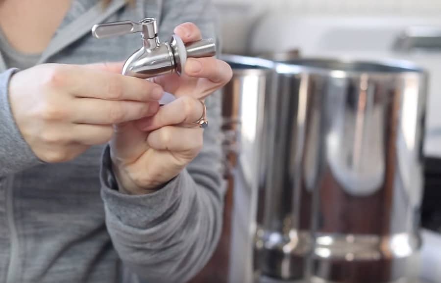 placing metal washer and silicon gasket onto stainless steel spigot