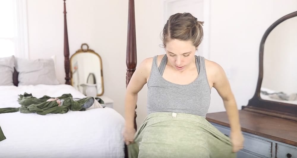 women wearing gray tank top is placing a DIY woven wrap over her stomach