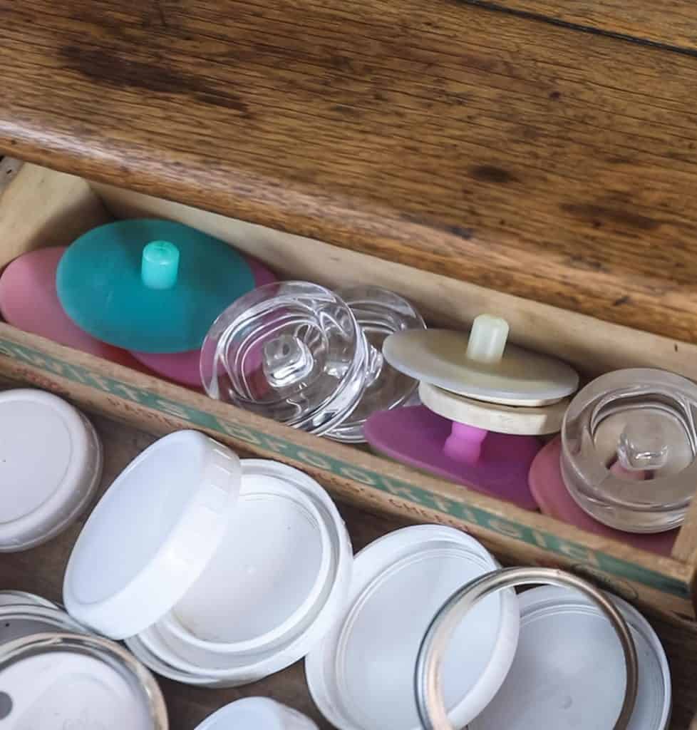 mason jar lid storage with a small antique box full of fermenting lids
