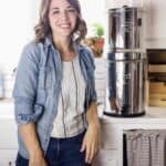 A woman standing next to a counter top with a boroux water filter on it.