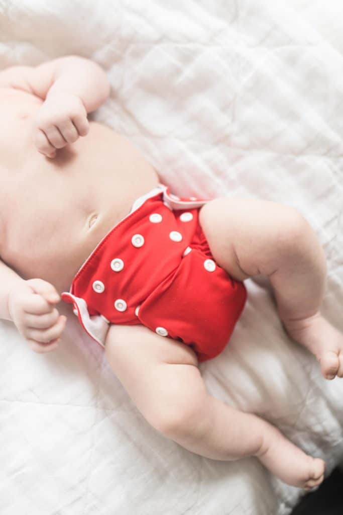 two month old baby wearing a red newborn cloth diaper