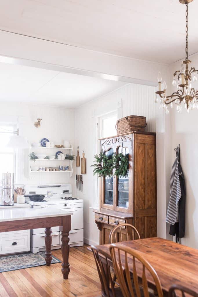 farmhouse kitchen table with antique brass chandelier. Victorian farmhouse kitchen in the background