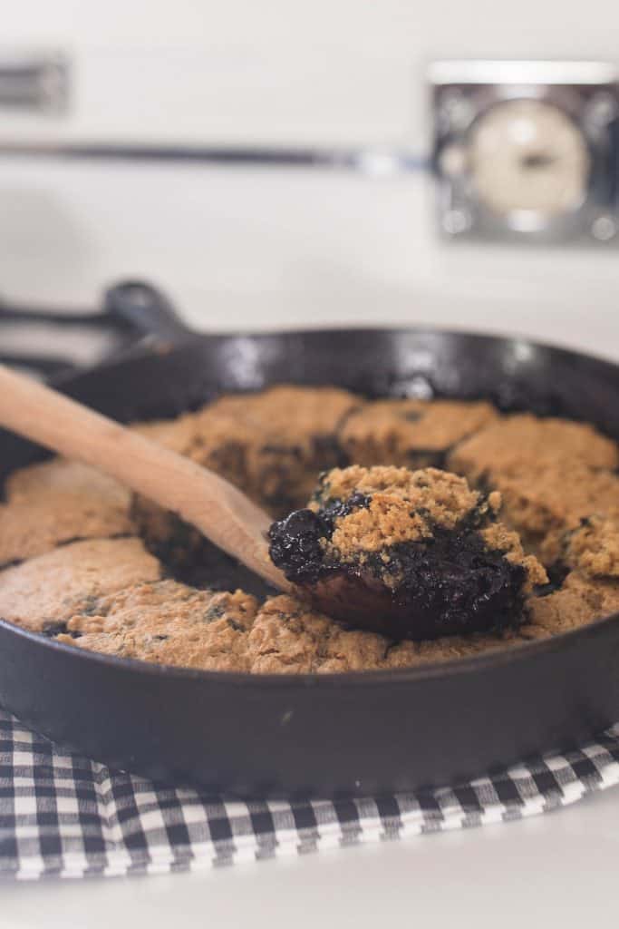 sourdough blueberry cobbler in a cast iron skillet straight out of the oven