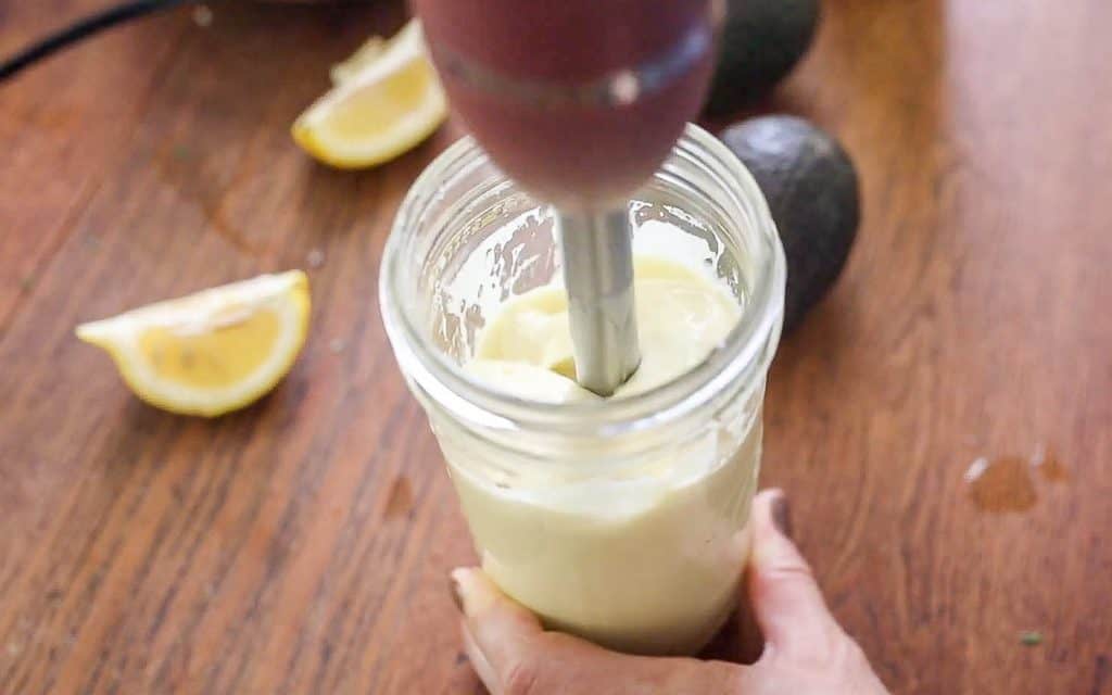 Homemade avocado mayo in a mason jar with a immersion blender