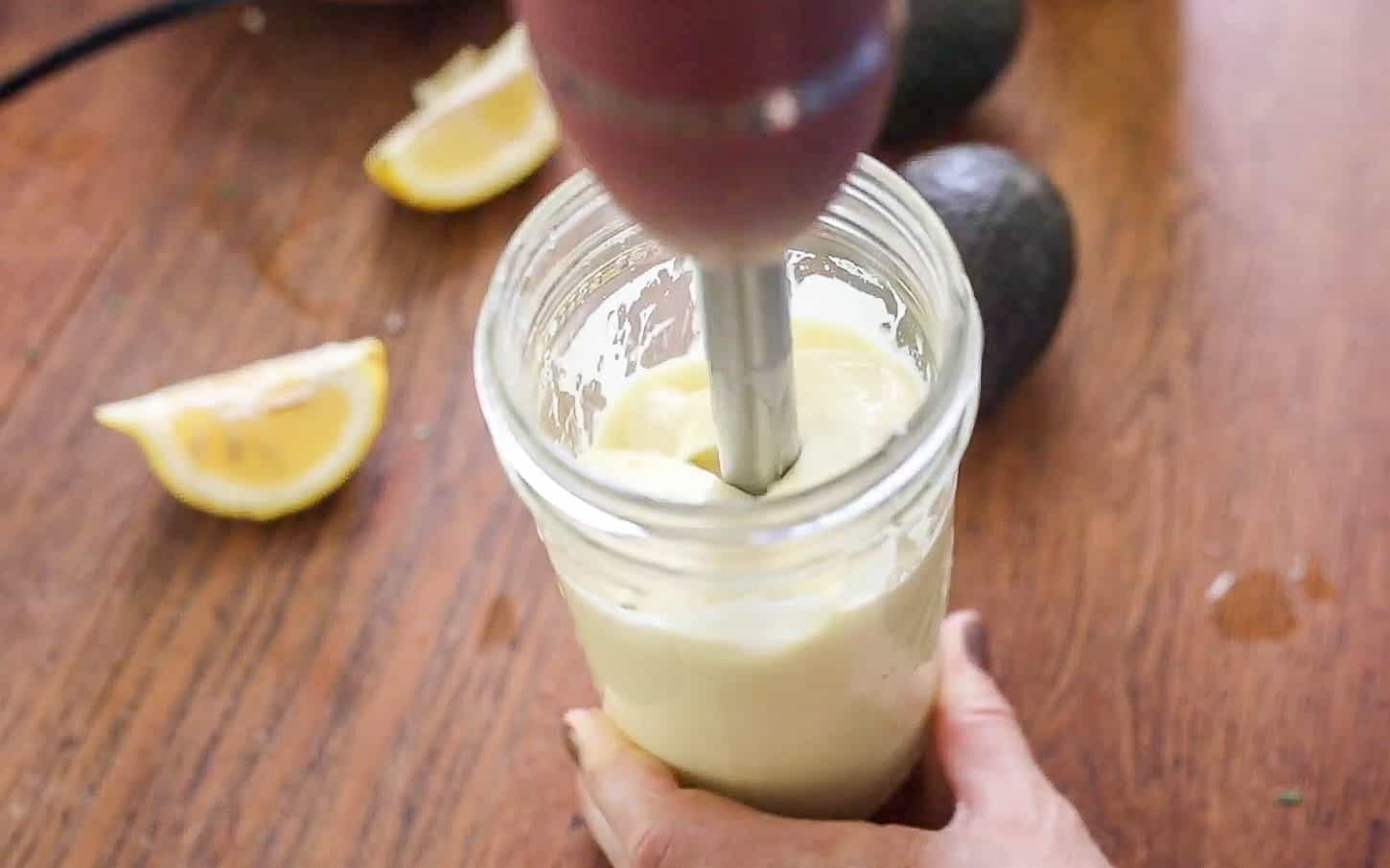 Mixing cilantro lime dressing in a mason jar with an immersion blender.