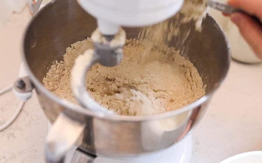 adding flour to a stand mixer