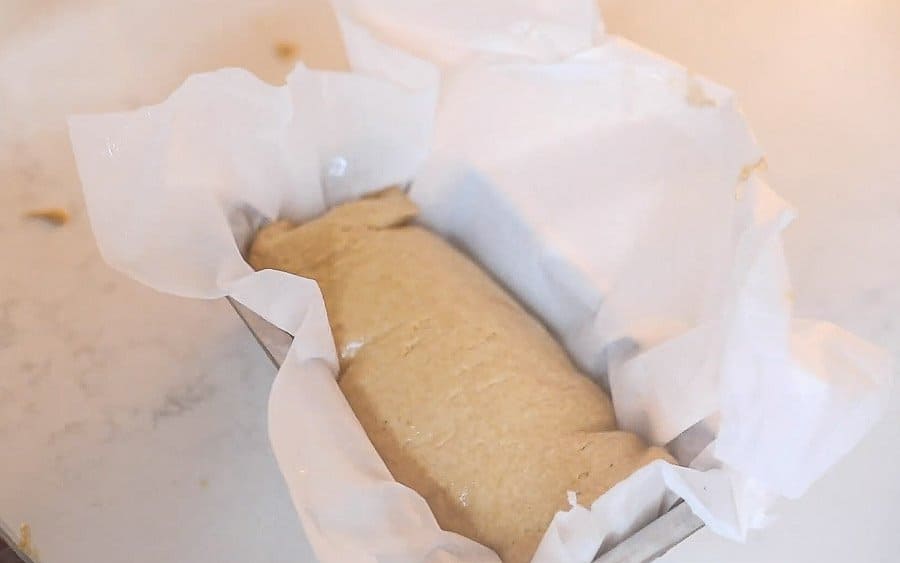 einkorn bread dough in a parchment lined bread loaf pan