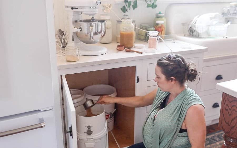 women grinding wheat berries in a flour grinder