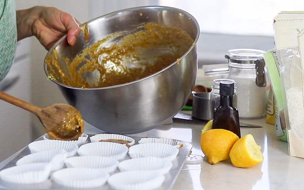 pouring muffin batter into lined muffin tins