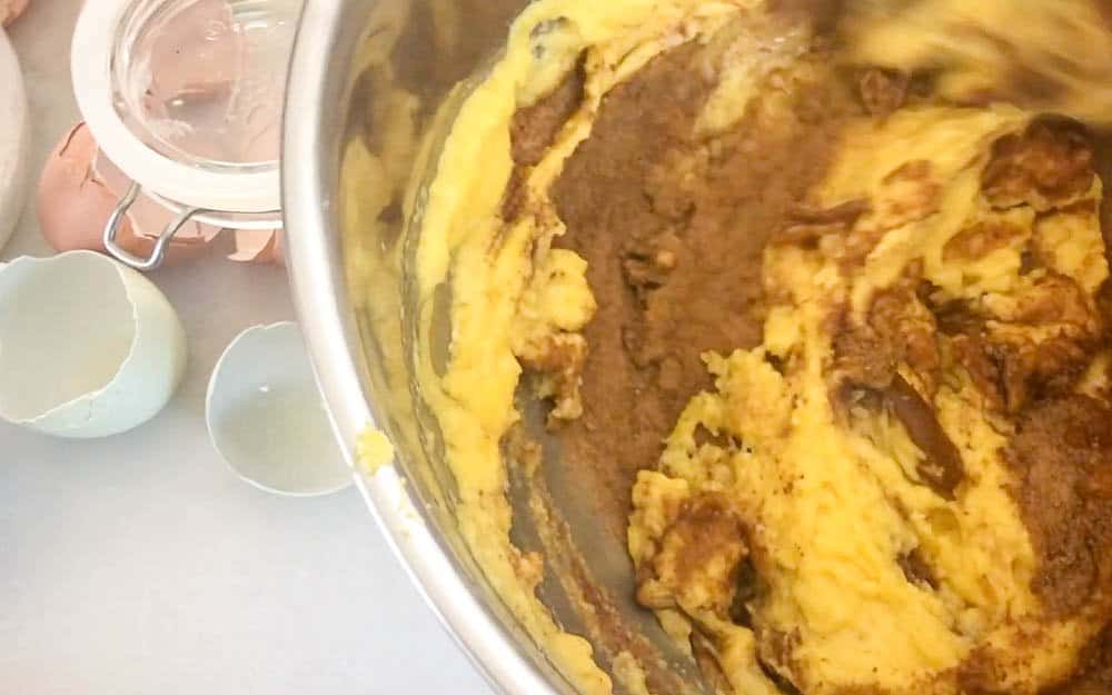 lemon poppyseed muffin batter in a stainless steel bowl. Egg shells to the left.