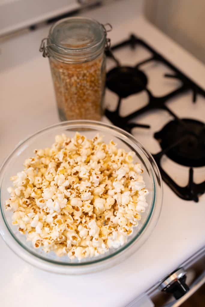 popcorn in a glass bowl on top a stove-top