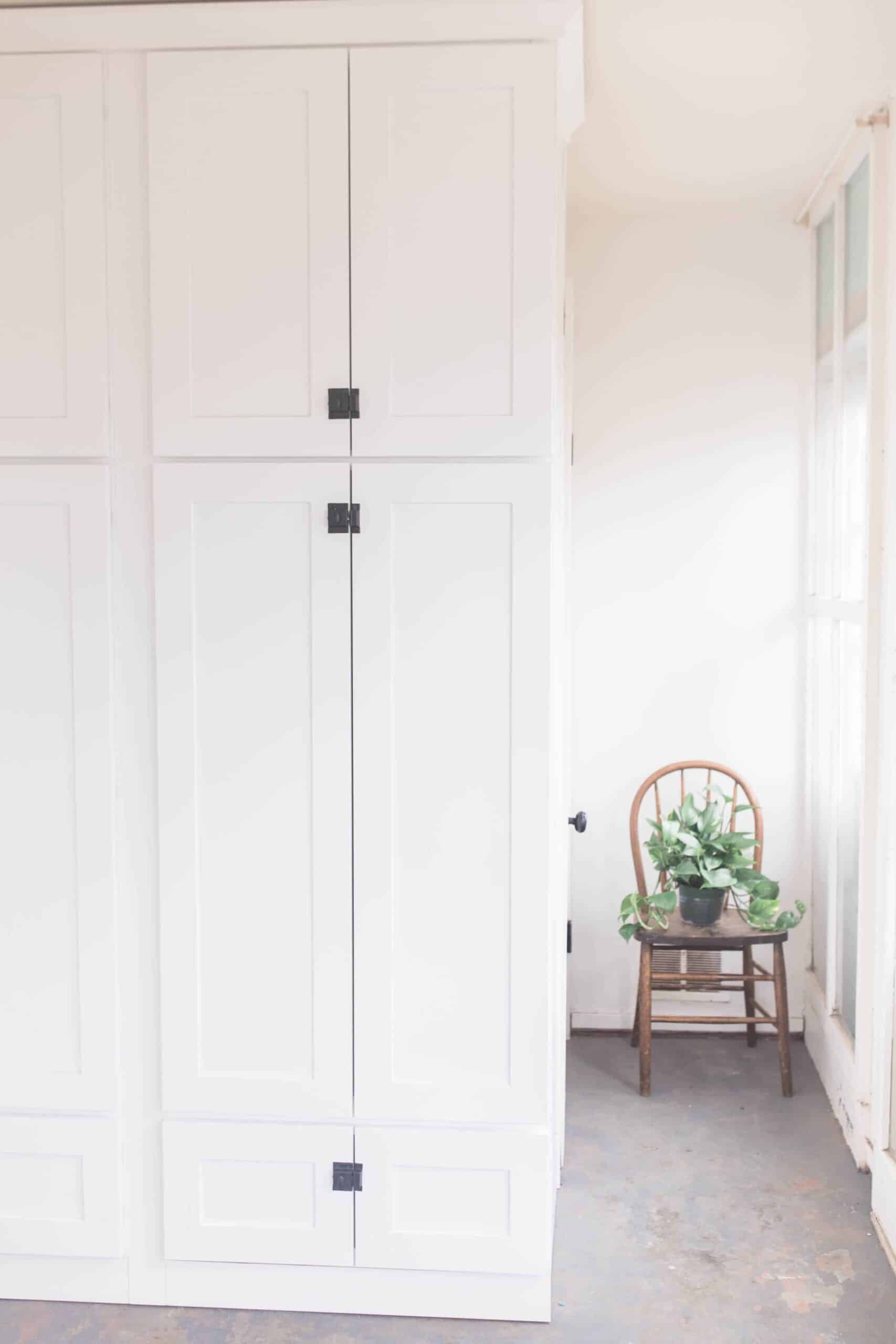 large white cabinets with black latches for farmhouse mud room organization