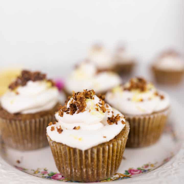coconut flour lemon poppy seed muffins topped with whipped cream, toasted coconut and pink flowers