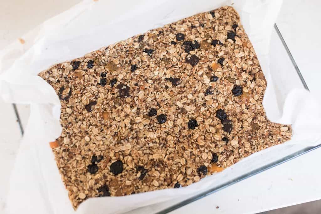 homemade granola bars pressed into a pan ready to go in the oven.