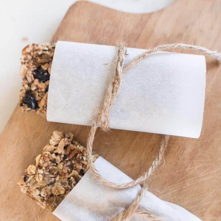 rustic granola bars wrapped in parchment paper and tied with twine on a cutting board