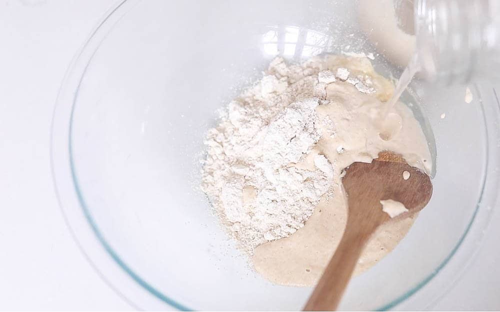 flour, coconut oil, and sourdough starter in a glass bowl 