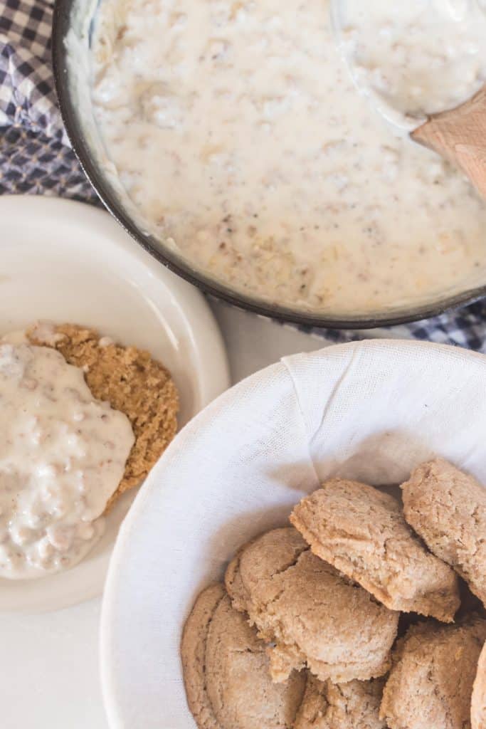 bowl of sourdough biscuits with sausage gravy in the background