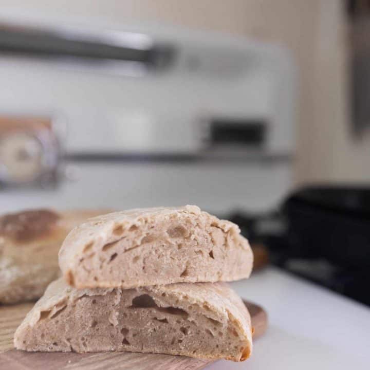two slices of sourdough ciabatta bread on a cutting board on a white stove