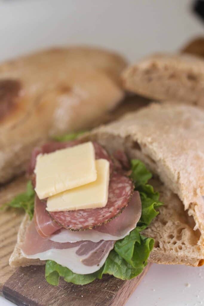 prosciutto, salami, lettuce, and cheese on sourdough ciabatta bread