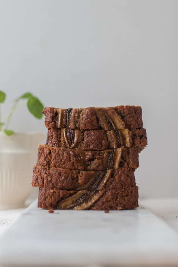 5 slices of sourdough banana bread stack up on a Marple cutting board