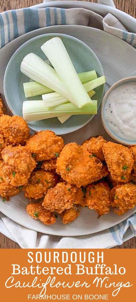 sourdough battered buffalo cauliflower wings on a gray plate with a side of teaser dipping sauce and a bowl full of celery sticks