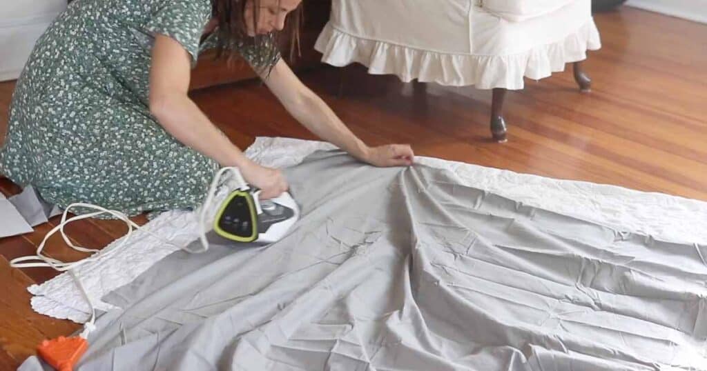 women ironing fabric on the floor