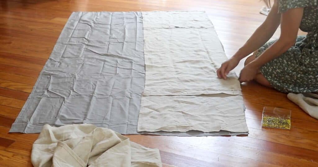 women sitting on the floor pinning a bed skirt panels to the top sheet