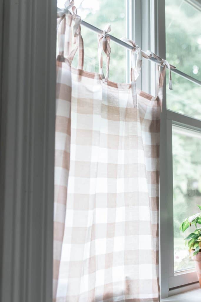 diy cafe curtains peach and white buffalo check hanging on a tension rod in a kitchen window