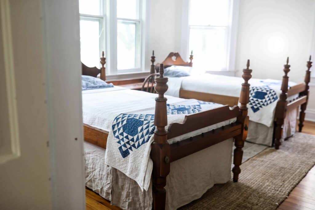 two antique wood beds with diy bed skirts made from linen