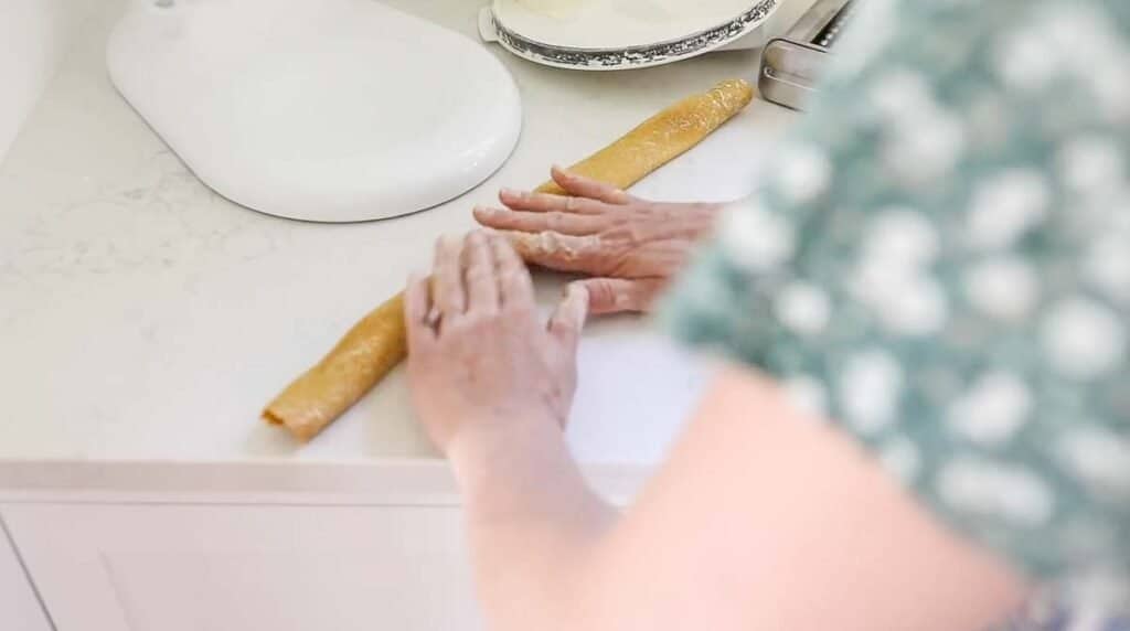women folding pasta dough into thirds