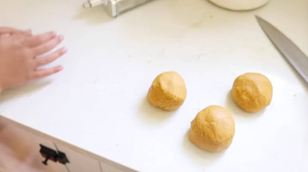 balls of einkorn pasta dough on a white countertop