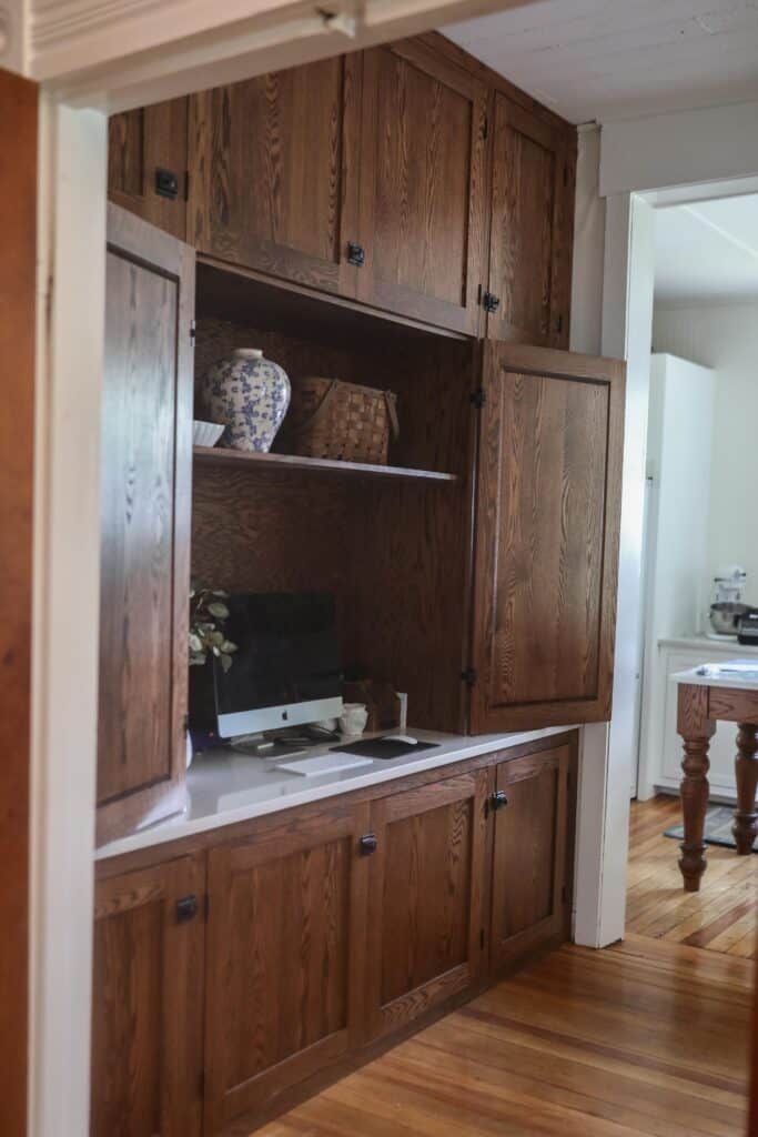 wood cabinet doors open to reveal an organized office