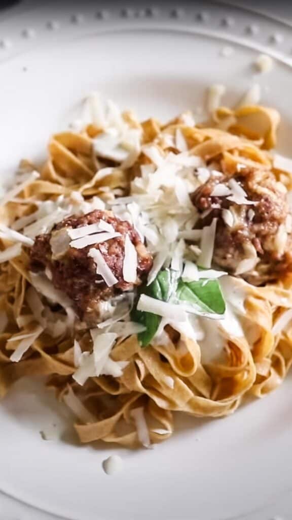 einkorn pasta with meatballs topped with cheese and basil