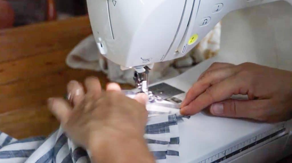 women using sewing machine to sew sleeve onto main body piece