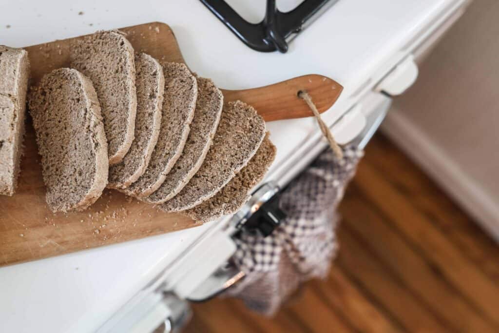rye bread sliced onto a wood cutting board on an antique stove
