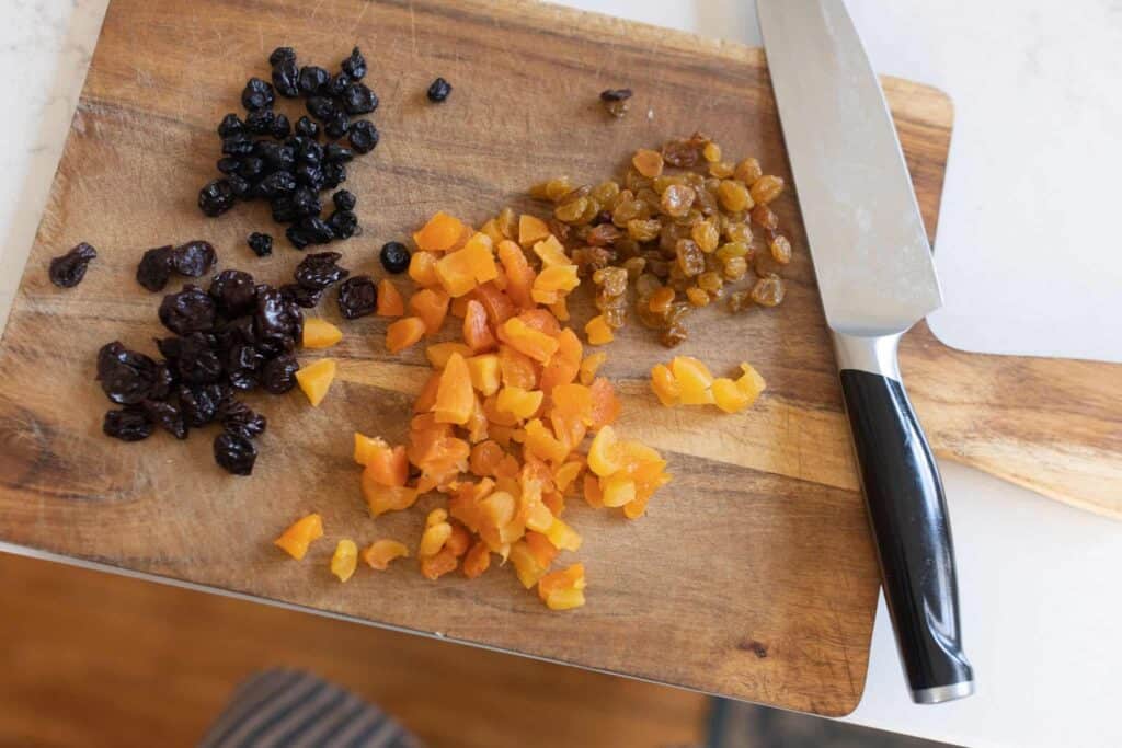 dried fruit on a cutting board being chopped with a knife