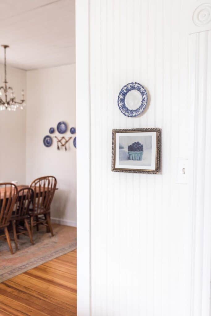 blueberry print in a antique frame with a blue and white plate hanging above it