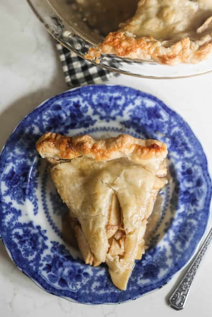 slice of apple pie with sourdough crust on a blue and white antique plate