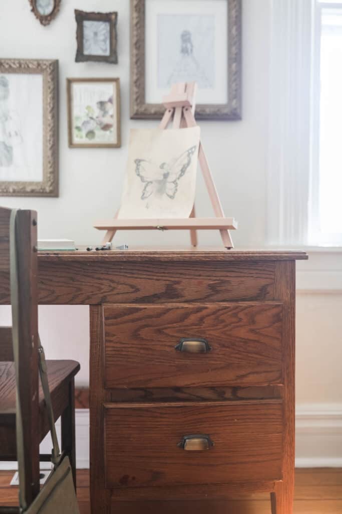 wooden desk with an easel with a drawing on it