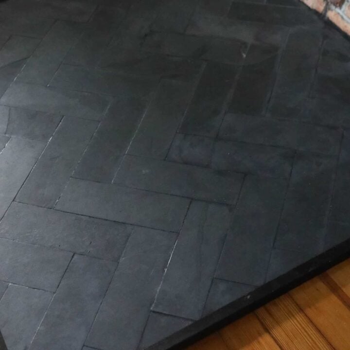 close up picture of a DIY hearth pad with slate tile in a herringbone pattern