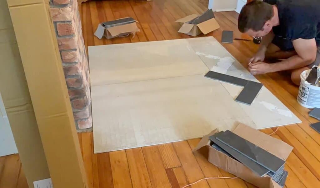 man laying black slate in a herringbone pattern