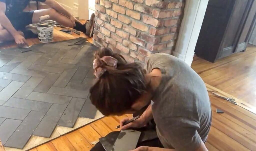 women marking black slate to lay on a hearth